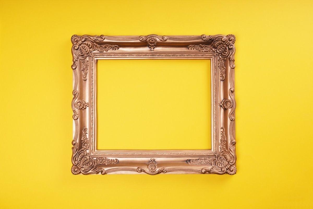 Empty Ornate Gold Picture Frame on Yellow Wall