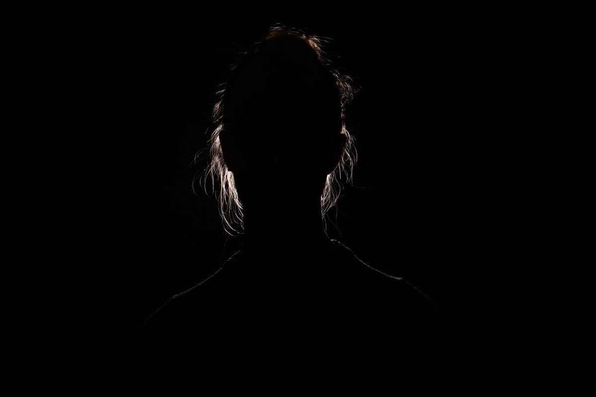 Backlit Portrait Silhouette of Unrecognizable Woman Hiding Face and Identity